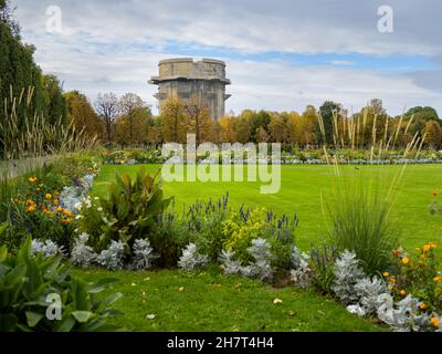 Tour antiaérienne de la Seconde Guerre mondiale dans le parc Augarten à Vienne (Autriche) lors d'une journée nuageux en été, fleurs en premier plan Banque D'Images
