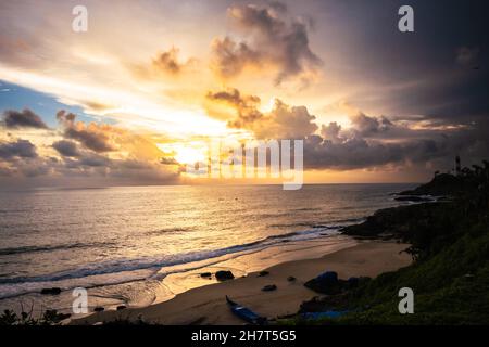 Comme le soleil se cache derrière les nuages sur l'horizon.La lumière déchaîne le ciel pour briller une lueur sur la plage. Banque D'Images