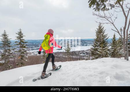 Raquette sur les gens dans la forêt d'hiver avec des arbres couverts de neige le jour de neige.Femme en randonnée dans la neige randonnée en raquettes vivant en plein air actif sain Banque D'Images