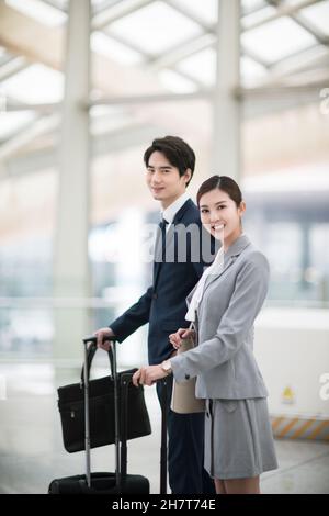 Les gens d'affaires qui marchent avec des valises à l'aéroport Banque D'Images