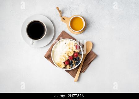 Petit déjeuner servi le matin : crêpes, porridge, fromage cottage, granola, muesli,jus d'orange, thé, café, fruits et baies. Banque D'Images