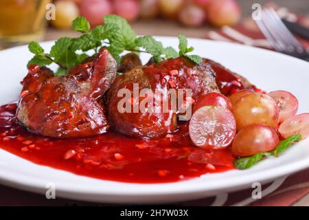 Salade chaude avec foie de poulet et raisins sur l'assiette.Salade chaude de foie de dinde.Salade chaude avec foie de poulet et sauce à la framboise. Banque D'Images