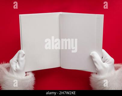 Le Père noël tient un livre avec des pages vierges.Maquette de Noël Banque D'Images