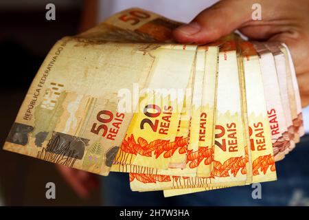 Plusieurs notes brésiliennes réelles d'une main Banque D'Images