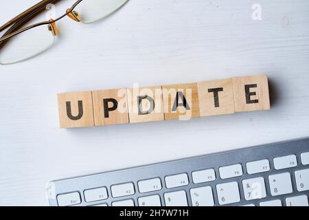 Le concept de mise à jour du logiciel écrit sur des cubes en bois à côté du clavier Banque D'Images