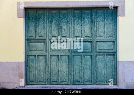 Doubles portes de garage en bois fissurées et écaillées en vert Banque D'Images