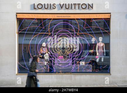 25 novembre 2021.Une jeune femme passe devant l'exposition de fenêtres Louis Vuitton de Noël dans le magasin New Bond Street. Banque D'Images