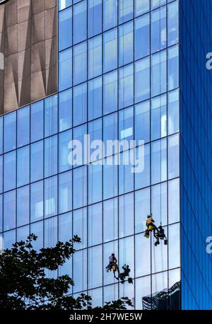 Varsovie, Mazovia / Pologne - 2020/08/09: Nettoyants pour murs de verre accrochés à la surface de la tour Q22 de bureau d'Echo Investment à al Avenue Jana Pawla II à Do Banque D'Images