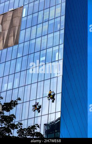 Varsovie, Mazovia / Pologne - 2020/08/09: Nettoyants pour murs de verre accrochés à la surface de la tour Q22 de bureau d'Echo Investment à al Avenue Jana Pawla II à Do Banque D'Images