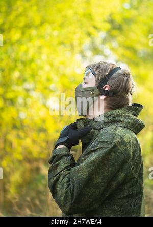 Portrait d'hommes militaires entièrement équipés dans un masque de sécurité avec des armes automatiques se préparer à jouer au strikeball aérosoft Banque D'Images