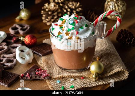 Vue rapprochée d'une tasse de chocolat chaud surmontée de crème fouettée et de saupoudrer. Banque D'Images