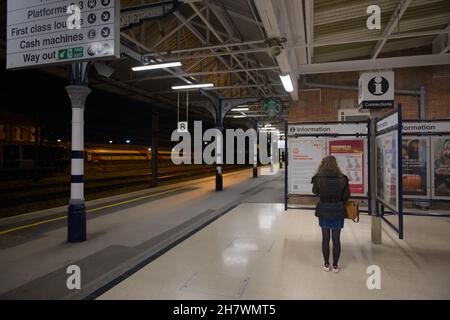Doncaster, Royaume-Uni, 22 mai 2021: Image grand angle de la plate-forme de la gare de doncaster numéro 8 la nuit.Femme lit le point d'information. Banque D'Images