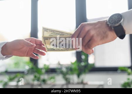 KIEV, UKRAINE - 22 SEPTEMBRE 2021 : vue rognée d'un homme d'affaires donnant de l'argent pot-de-vin à une femme, concept anti-corruption Banque D'Images