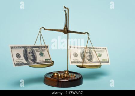 KIEV, UKRAINE - 22 SEPTEMBRE 2021 : la justice pèse avec des billets en dollars sur fond bleu, concept anti-corruption Banque D'Images