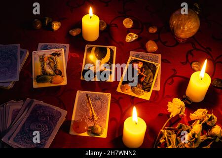 Minsk, Bélarus - novembre 2021 : le récit de fortune sur des cartes de tarot avec des bougies et des pierres.Magie et occultisme. Banque D'Images