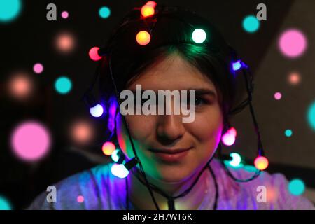 Fête de Noël.Gros plan fou bonne jeune femme célébrant noël.Les jeunes s'amusent pendant les vacances d'hiver avec des lumières colorées.Femme wr Banque D'Images