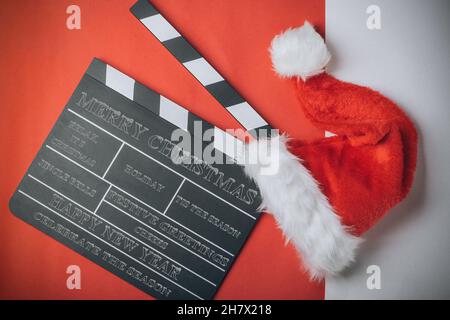 Chapeau de Noël avec découpe de film sur fond rouge et blanc. Avec messages.Concept de film de Noël Banque D'Images