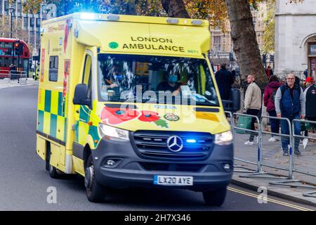 Les piétons regardent une ambulance rapide passer avec les feux bleus clignotants, Westminster, Londres, Royaume-Uni Banque D'Images