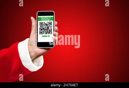 Le Père Noël affiche le code QR sur le smartphone vacciné COVID-19 ou certificat du coronavirus, passeport du vaccin d'immunité. Banque D'Images