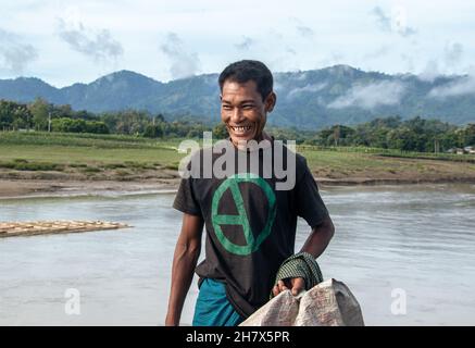 Un homme tribal riant sur la rive de la rivière Matamuhuri . Banque D'Images