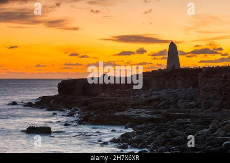 Portland Bill, Dorset, Royaume-Uni.25 novembre 2021.Météo Royaume-Uni.Le ciel brille d'orange au-dessus de l'obélisque de Portland Bill à Dorset au coucher du soleil à la fin d'une journée froide et claire.Crédit photo : Graham Hunt/Alamy Live News Banque D'Images