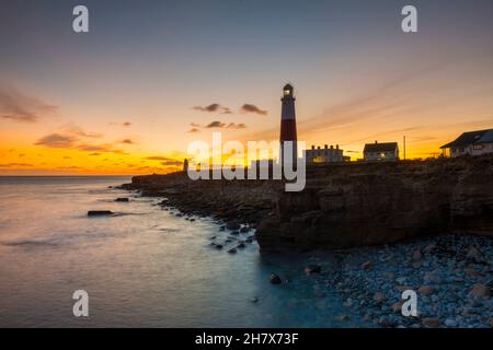 Portland Bill, Dorset, Royaume-Uni.25 novembre 2021.Météo Royaume-Uni.Le ciel au-dessus du phare brille d'orange à Portland Bill à Dorset au coucher du soleil à la fin d'une journée froide et claire.Crédit photo : Graham Hunt/Alamy Live News Banque D'Images