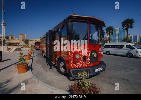 Dubaï, Émirats arabes Unis 17 février 2020 : anciens bâtiments de Dubaï et rue arabe.Quartier historique d'Al Fahidi, Al Bastakiya. Beau bus rouge touristique à l'arrêt contre de la mosquée Banque D'Images