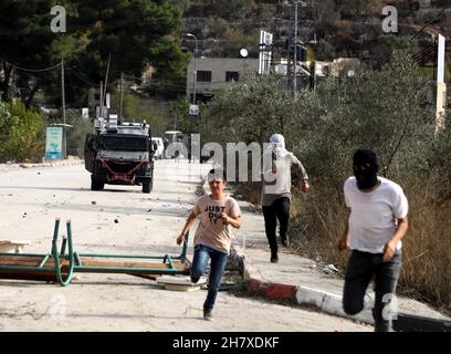 Naplouse, Palestine.25 novembre 2021.25 novembre 2021 : Naplouse, Cisjordanie, territoires palestiniens.25 novembre 2021.Des affrontements éclatent entre l'armée israélienne et des jeunes Palestiniens dans la ville d'Al-Lubban al-Sharqiya, près de Naplouse, pour protester contre les attaques des colons contre les écoles palestiniennes de la région.Selon des sources locales, des colons et des forces israéliennes ont agressé jeudi matin des étudiants palestiniens qui se rendirent à l'école dans le village d'Al-Lubban Ash-Sharqiya.Il fait suite à plusieurs attaques de ces derniers jours par des colons israéliens protégés par l'armée à la haute école AS-Sawiya et au haut-sc al-Lubban Banque D'Images