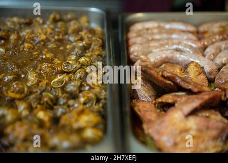 Présentation d'un plat à emporter avec deux plateaux de différents types de viande et d'escargots Banque D'Images