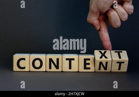 Symbole de contenu et de contexte.Homme d'affaires tourne des cubes en bois et change le mot contexte en contenu.Belle table grise, fond gris.Affaires an Banque D'Images