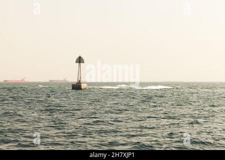 La tour de balise est à la frontière d'un fairway, structure encadrée avec des stands de triangle de haut de marque dans l'eau du golfe Persique, Arabie Saoudite Banque D'Images