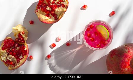 Cocktail d'été avec grenade sur table blanche Banque D'Images