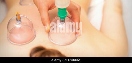Femme recevant un traitement par immersion sous vide sur le dos couché sur la poitrine dans le salon de massage Banque D'Images