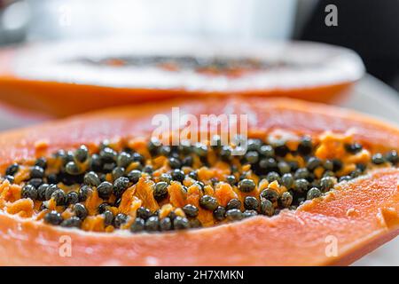 Macro-gros plan de la coupe fraîche dans la moitié des fruits papaye mûrs avec des graines à l'intérieur sur la table de cuisine maison ou l'affichage des stalle de marché des agriculteurs Banque D'Images
