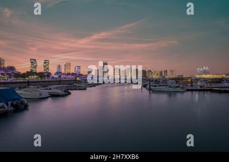 Lusail marina dans la ville de Lusail, Qatar au coucher du soleil avec Yachts et bateaux, horizon de Lusail et nuages dans le ciel en arrière-plan Banque D'Images