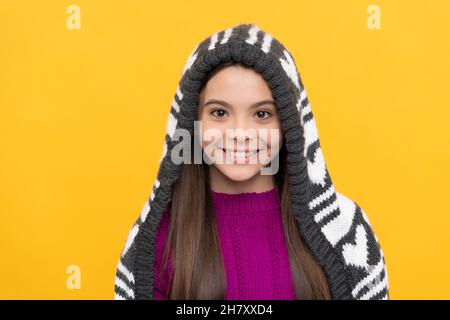 joyeux enfant dans un chapeau à rabat sur fond jaune, hiver Banque D'Images