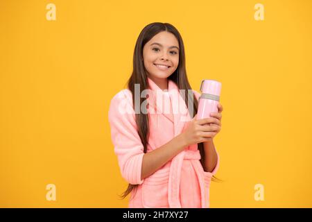 bonne fille de l'adolescence dans la maison en tissu éponge peignoir avec bouteille de thermos, le matin Banque D'Images