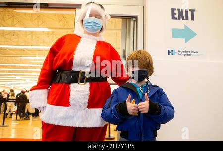 Toronto, Canada.25 novembre 2021.Un enfant pose pour des photos avec une femme habillée comme le Père Noël après avoir été vaccinée dans une clinique de vaccination à Toronto, Canada, le 25 novembre 2021.La ville de Toronto a commencé jeudi la vaccination COVID-19 pour les enfants âgés de 5 à 11 ans qui ont confirmé leur rendez-vous.Credit: Zou Zheng/Xinhua/Alamy Live News Banque D'Images