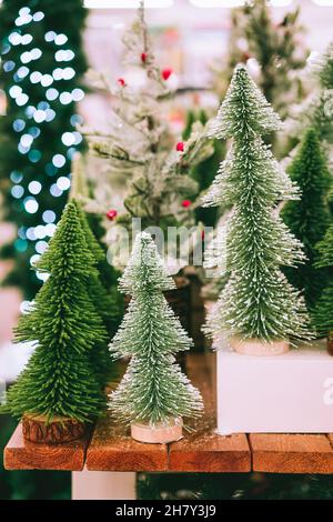 Arbres artificiels décoratifs de Noël et du nouvel an sur le comptoir dans le magasin sur le marché de Noël.Préparation pour les vacances d'hiver.Carte verticale Banque D'Images