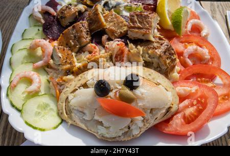 Déjeuner avec salade de crabe froid et de fruits de mer, accompagné de crevettes, coquillages, concombres et tomates, servi dans un restaurant de Norfolk, East Anglia, Angleterre Banque D'Images