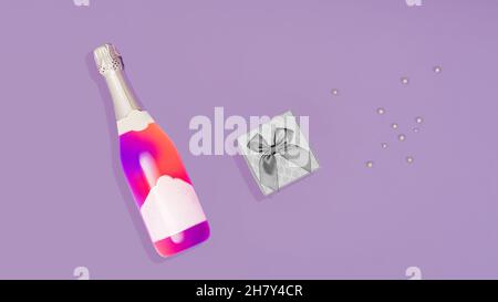 Décoration de Noël au néon pastel.Célébration NY.Bouteille de champagne au néon.Rose et violet fluo en contraste avec le fond de lilas pastel.Cadeau gris et Banque D'Images