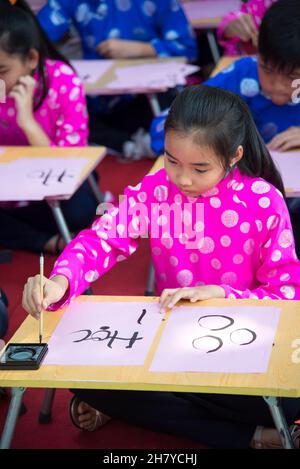 Les enfants vietnamiens apprennent à écrire la calligraphie à l'occasion des vacances de Tet. Banque D'Images