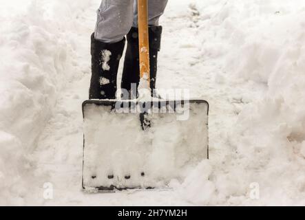 Un homme nettoie les chemins dans la cour de la neige Banque D'Images