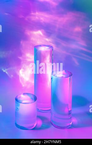trois podiums en verre transparent sur fond rose pastel Banque D'Images