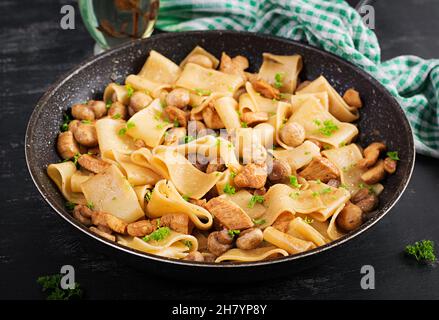 Pâtes Calamarata à la viande de poulet, aux champignons et à la sauce soya.Cuisine italienne. Banque D'Images
