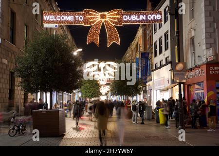 Dublin, Irlande - 24 novembre 2021 : les acheteurs marchent sous les lumières de Noël récemment illuminées sur Grafton Street, la principale artère commerçante de Dublin Banque D'Images