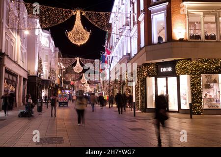 Dublin, Irlande - 24 novembre 2021 : les clients marchent sous les lumières de Noël récemment illuminées sur Henry Street, la rue commerçante sur le Banque D'Images