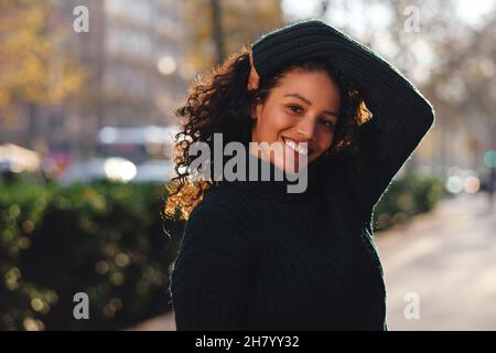 Femme souriant en posant à l'extérieur. Banque D'Images