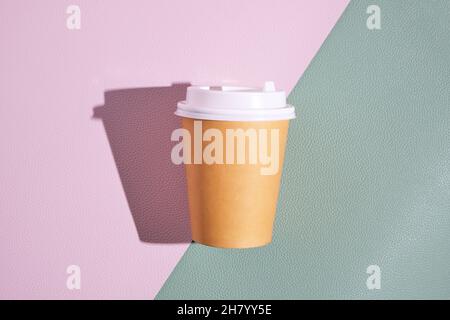 Gobelet jetable en papier pour le café chaud et le thé sur fond vert rose. Concept et tendance de la nourriture à emporter Banque D'Images