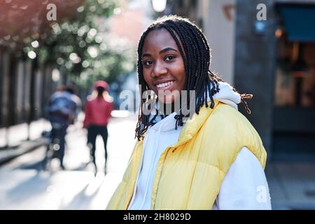 Jeune femme souriant debout à l'extérieur. Banque D'Images